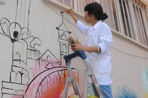 Resim öğretmenleri fırçalarıyla okul duvarlara  eğitici resimler yapıyor