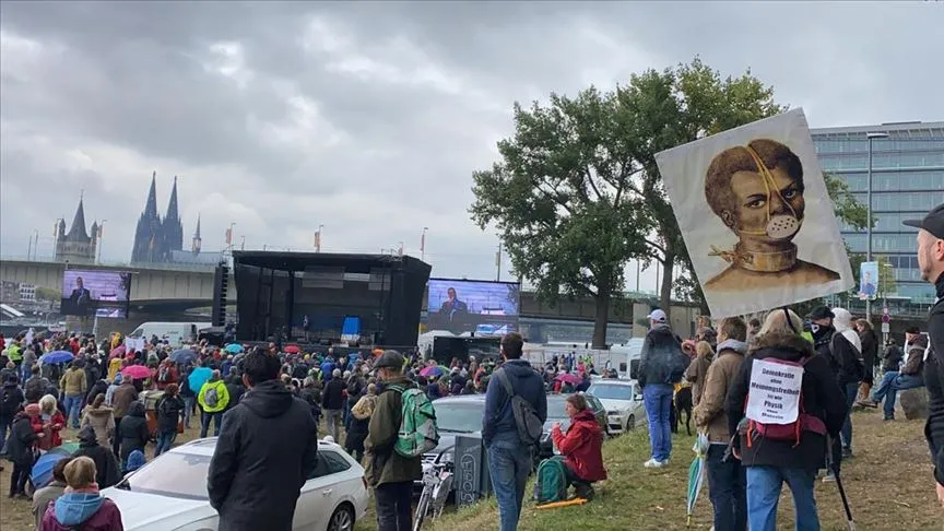 Almanya'nın Köln kentinde binlerce kişi, hükümetin uyguladığı yeni tip koronavirüs